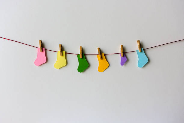 World Prematurity day concept. Normal size and Tiny socks on a red rope