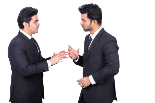 Businessmen having a conversation on white background. Handsome Indian young male business partners are wearing suits. They are discussing on new project.