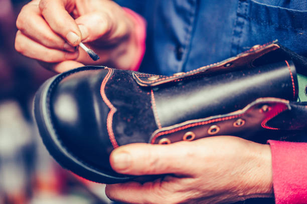 istock Hands of an experienced worker putting paint on the shoe. 1184638188