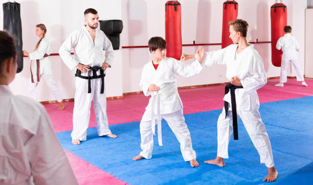 istock Kids in kimonos exercising techniques in pair during taekwondo c 1184638470