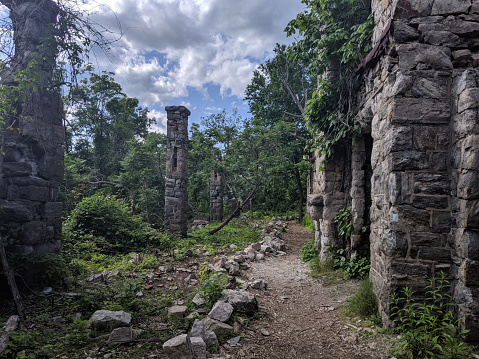 Oakland, New Jersey/USA - May 27 2019: Van Slyke Castle ruins hidden in the woods at Ramapo Reservation. New Jersey. Haunting remains of Foxcroft from 1900's.