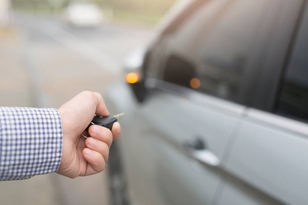 istock Men pressing hands on the remote control car alarm system Car theft alarm concept 1184642360