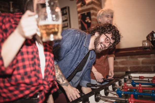 amigos que jogam o futebol da tabela no clube de noite - club soccer fotos - fotografias e filmes do acervo