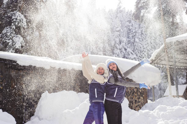 istock Two girlfriends have fun and enjoy fresh snow on a beautiful winter day 1184648200