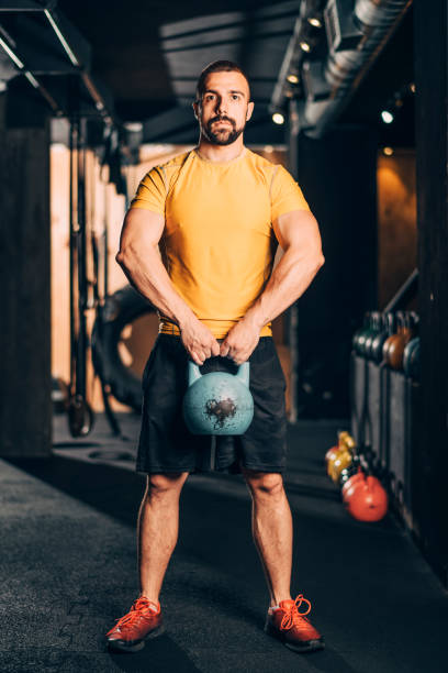 istock Muscular athlete doing a kettlebell shoulder workout in a   gym 1184649198