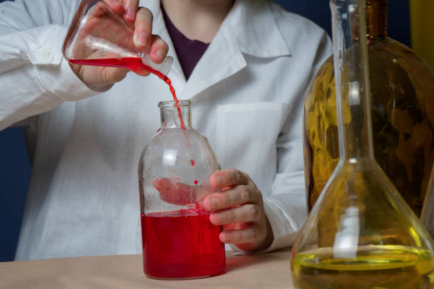 istock Lab female medical or scientific laboratory researcher performs tests with red liquid. Close up 1184652735