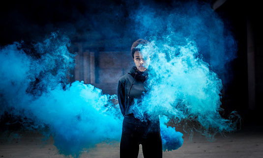 Portrait of a young woman in blue smoke