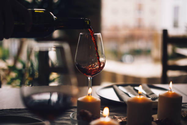 グラスに注がれている赤ワイン - ワインボトル 写真 ストックフォトと画像