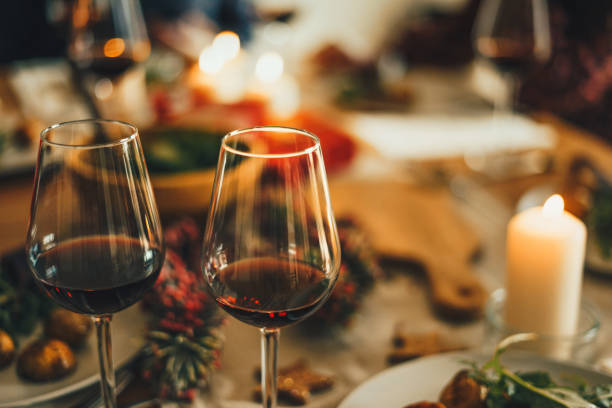 Red wine at the Christmas dinner table Close up shot of red wine glasses at Christmas dinner table. candle light dinner stock pictures, royalty-free photos & images