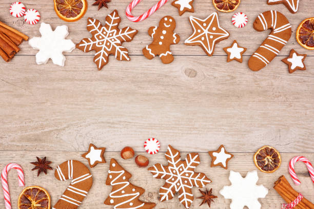 istock Christmas gingerbread cookies, candy and baking items, double border on a wood background 1184659558
