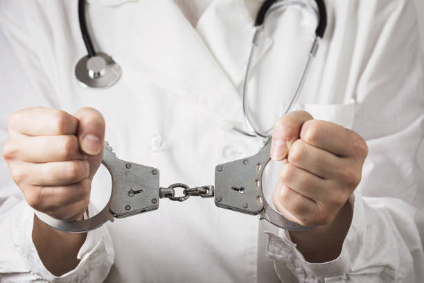 Handcuffed doctor, close-up. Medical malpractice and error concept stock photo