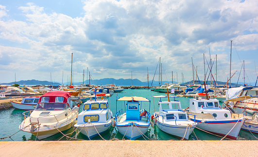 Moored up fishing boats abreast by wharf in the port of Aegina,  Greece - Panoramic view