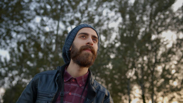 istock Handsome young hipster man with leather jacket on his head wearing winter cap, looking at the horizon. 1184671035