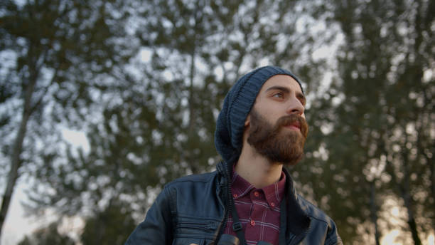 istock Handsome young hipster man with leather jacket on his head wearing winter cap, looking at the horizon. 1184671612