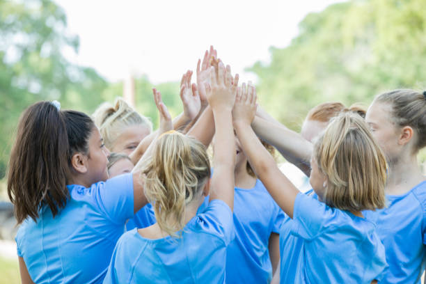 istock Team of girls huddle and celebrate on sidelines 1184676335