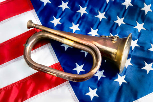 Old brass Bugle. Old brass bugle on the American flag. bugling photos stock pictures, royalty-free photos & images
