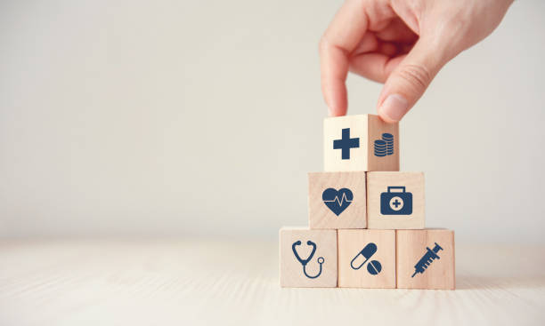 Health Insurance Concept, Reduce Medical Expenses, Hand flip wood cube with icon healthcare medical and coin on wood background, copy space. Health Insurance Concept, Reduce Medical Expenses, Hand flip wood cube with icon healthcare medical and coin on wood background, copy space. patient blood management stock pictures, royalty-free photos & images
