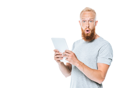 handsome shocked man using digital tablet, isolated on white