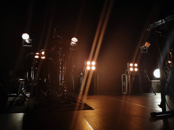 palco da concerto e apparecchi di illuminazione su di esso, attrezzature musicali. il fumo di un impianto di fumo rompe delicatamente la luce gialla e crea l'effetto di un bagliore delicato. - luce di palcoscenico foto e immagini stock