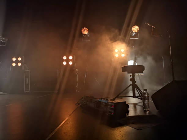 Concert stage and lighting fixtures on it, musical equipment. Smoke from a smoke installation gently breaks yellow light and creates the effect of a gentle glow. stock photo