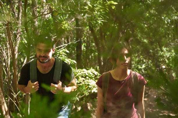 istock Young couple walking in a lush green forest 1184682388