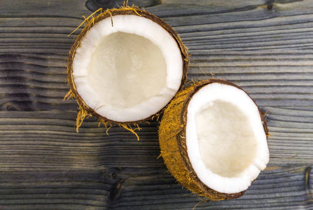 istock Top view of Half cut coconut on a rustic wooden table 1184690063