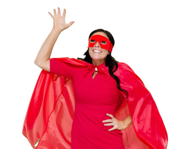 front view / one person / waist up / portrait of adult beautiful black hair caucasian female / young women superhero / heroines / hero standing wearing dress / eye mask / mask - disguise / costume / cape - garment / cool attitude and celebration - thank you excitement waist up horizontal imagens e fotografias de stock