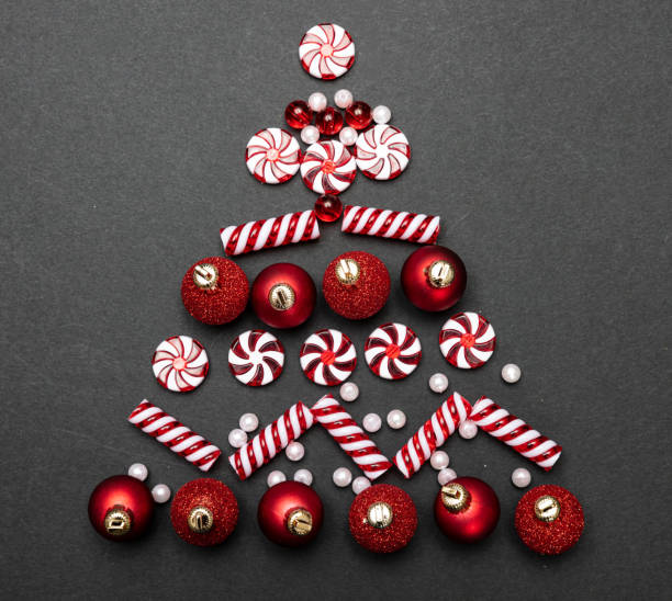 istock Xmas baubles in tree shape against black background, top view 1184691701
