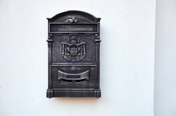 istock Close up view of an old black mailbox with ancient logo hanging on a wall. Copy space 1184692190