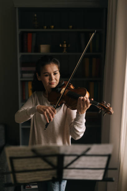 istock Beautiful female looks at the score while playing the violin 1184694384