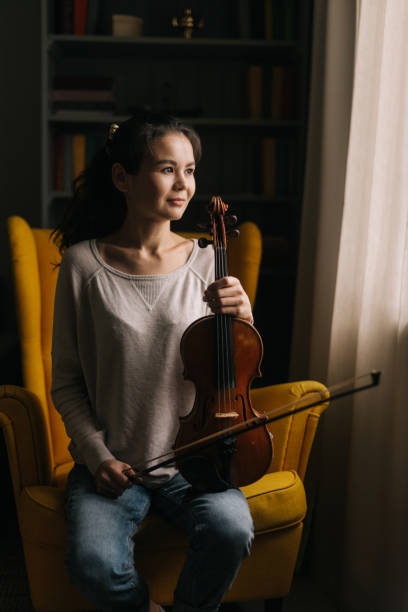 istock Beautiful young woman posing with a violin in her hand 1184694577