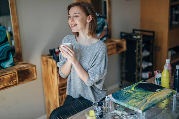 istock Happy female artist drinking coffee 1184698702