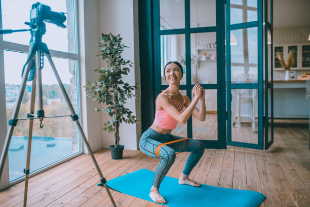 istock Fitness trainer doing sit ups with resistance band in front of camera 1184699882