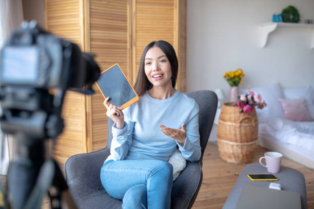 istock Blogger holding tablet while filming blog about freelance 1184699981