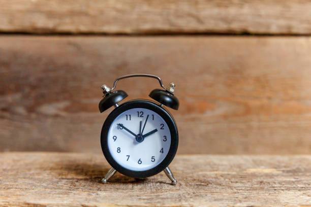 istock Vintage alarm clock on wooden background 1184703171