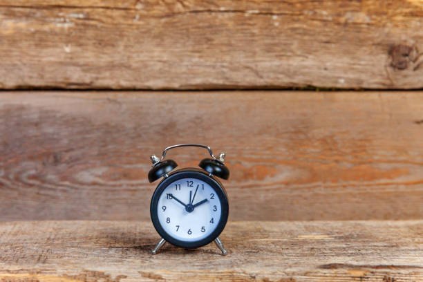 istock Vintage alarm clock on wooden background 1184703194