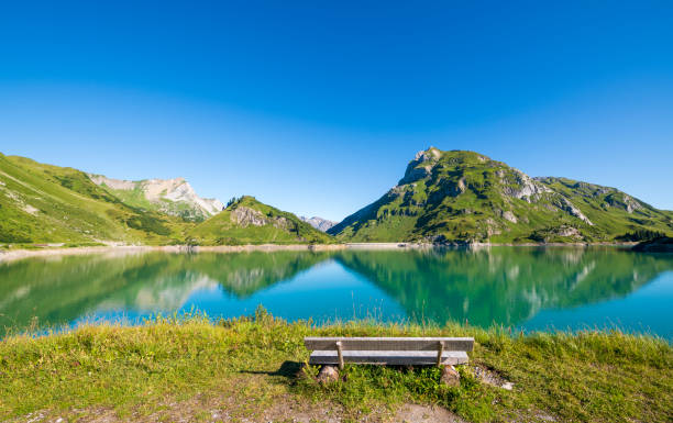 A bench in front of the lake Spullersee reservoir in the Lech valley in Vorarlberg, Austria.