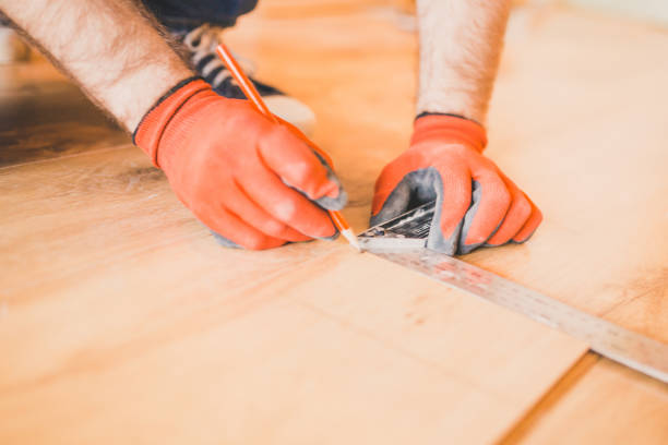 istock Man installing new laminated wooden floor 1184703392