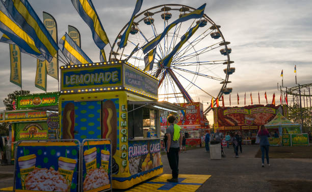 purchasing popcorn under ferris wheel at american fair carnival - carnival amusement park amusement park ride traditional festival imagens e fotografias de stock