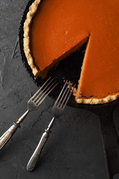 istock Traditional open pumpkin pie on black background top view copy space. Thanksgiving home baking concept 1184704610