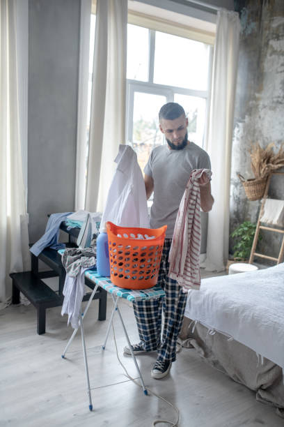 istock Bearded man preparing clothes for laundry at the weekend 1184704756