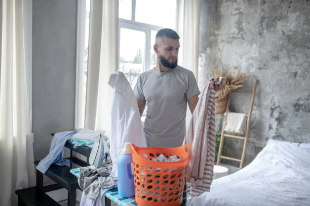 istock Businessman gathering clothes for laundry at the weekend 1184704757