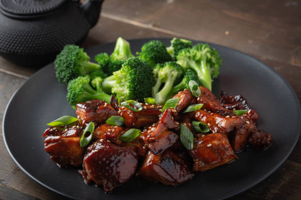 istock teriyaki chicken and broccoli on black plate 1184706237