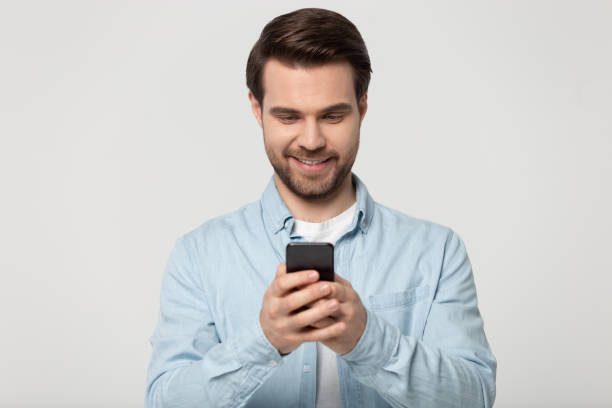istock Smiling young man reading pleasant message from beloved woman. 1184709968