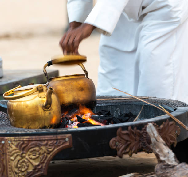 istock beduin tradition, roasting and making arabic Coffeys and tea over the open fire place in the desert 1184711487