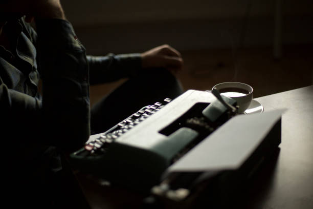 Thoughtful bearded stylish writer typing on typewriter
