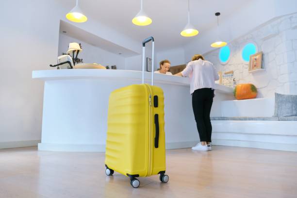 istock Yellow suitcase near reception desk in hotel lobby 1184716358