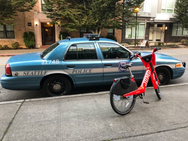 Seattle Seattle, USA - Oct 2, 2019: An Uber Jump ride-share bike early in the day parked next to a Seattle Police Vehicle. german social democratic party photos stock pictures, royalty-free photos & images