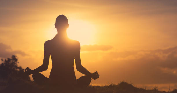 istock Woman meditating in a beautiful morning sunrise setting. 1184718491