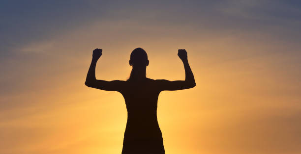 istock Strong, motivated woman flexing facing sunset. 1184718520
